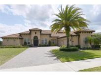 Beautiful Mediterranean home featuring a terracotta roof, manicured lawn, and a circular driveway with palm trees at 3764 Farm Bell Pl, Lake Mary, FL 32746