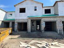 New construction townhomes featuring concrete block construction and attached garages, still awaiting finishing touches at 4303 Campsite Loop, Orlando, FL 32824