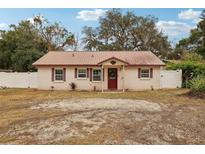 Single-story house with brown metal roof and red front door, surrounded by trees and a yard at 513 Seminole Ave, Fruitland Park, FL 34731