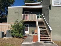 Exterior view of condo building with stairs leading to entrance at 6073 Windhover Dr # C04, Orlando, FL 32819