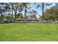 Ranch style home with a large front yard and mature trees at 126 Se 41St Ave, Ocala, FL 34471