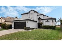 Two-story house with gray exterior, black shutters, and a well-manicured lawn at 127 Westmoreland Cir, Kissimmee, FL 34744