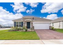 One-story home with brick paver driveway and landscaped front yard at 1550 Outback Rd, St Cloud, FL 34771