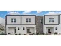 Modern townhome exterior with stone accents and contemporary design, offering sleek curb appeal at 388 Famagusta Dr, Davenport, FL 33896