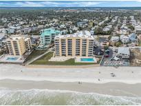 Aerial view of beachfront building, pool, and parking at 421 S Atlantic Ave # 105, New Smyrna Beach, FL 32169