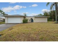 Ranch style home with a white garage door and well-maintained lawn at 507 Applewood Ave, Altamonte Springs, FL 32714