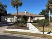 Charming single-Gathering home features an orange front door, attached garage, and a beautifully landscaped yard at 930 Brennam Pl, Longwood, FL 32750