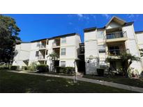 Two-story condo building with light-colored siding and landscaping at 1972 Lake Atriums Cir # 199, Orlando, FL 32839