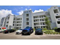 Apartment building exterior with parking and landscaping at 3151 Paradox Cir # 405, Kissimmee, FL 34746