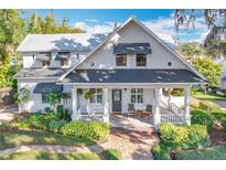 Charming two-story home featuring a cozy front porch, manicured landscaping, and classic architectural details at 527 Broadway Ave, Orlando, FL 32803