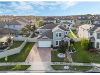 Beautiful two-story home with a brick driveway, manicured lawn, and fenced yard at 14190 Dove Hollow Dr, Orlando, FL 32824