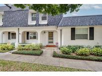 Charming white exterior of a townhome with gray roof and landscaping at 3117 Eagle Blvd # C, Orlando, FL 32804