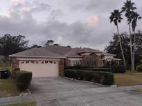 One-story brick home with attached garage and landscaped yard at 3860 Weetamoo Cir, Orlando, FL 32818