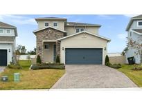 Two-story house with stone accents and a gray garage door at 4398 Davos Dr, Clermont, FL 34711