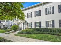 Gray townhome exterior with black shutters, landscaping, and sidewalk at 4487 Twinview Ln, Orlando, FL 32814