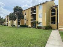 Condo building exterior with palm trees and grassy lawn at 5275 Images Cir # 306, Kissimmee, FL 34746