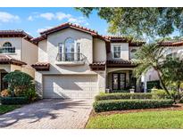 Two-story house with a light-colored facade, brown roof, and manicured landscaping at 8312 Via Rosa, Orlando, FL 32836