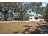 Two houses on a spacious lot with a long driveway, surrounded by lush trees at 1016 W Lake Marion Rd, Haines City, FL 33844