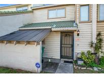 Tan colored townhouse exterior with a covered entryway and landscaping at 1350 Winter Green Way, Winter Garden, FL 34787