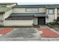 Two-story townhome with light-colored siding and a green roof at 1350 Winter Green Way, Winter Garden, FL 34787