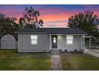 Newly renovated house with gray exterior, walkway, and a small shed at 1703 E Fern Rd, Lakeland, FL 33801