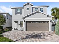 Two-story house with gray siding, brown garage door, and a paved driveway at 266 Southfield St, Kissimmee, FL 34747