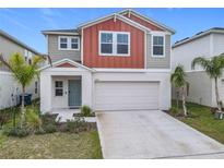 Two-story house with gray and burnt orange siding, two-car garage, and landscaping at 5381 Maddie Dr, Haines City, FL 33844