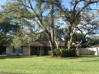 Brick house with mature oak trees and a well-maintained lawn at 749 E Yorkshire Dr, Deland, FL 32724