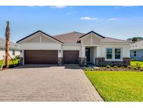 Charming single-story home featuring a two-car garage, paver driveway, and well-manicured lawn on a sunny day at 2987 Arranmore Dr, Ormond Beach, FL 32174