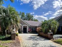Brick home with a paver driveway and lush landscaping at 5001 Latrobe Dr, Windermere, FL 34786
