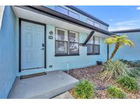Light blue condo building exterior with gray roof and palm trees at 67 Sabal Cay Court, New Smyrna Beach, FL 32169