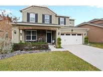 Two-story house with a two-car garage and landscaped front yard at 7043 Oxbow Rd, Minneola, FL 34715