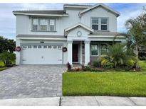 Two-story house with gray siding, white garage door, and landscaped lawn at 1445 Olympic Club Blvd, Champions Gate, FL 33896