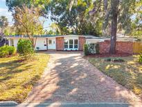 Brick ranch house with updated white accents and a brick driveway at 1640 Chinook Trl, Maitland, FL 32751