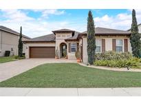 Beautiful one-story home with a brown door and landscaping at 1692 Highbanks Cir, Winter Garden, FL 34787