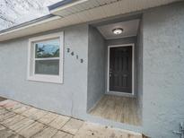 Newly renovated house exterior, featuring a gray facade and a modern front door at 2419 Rio Pinar Lakes Blvd, Orlando, FL 32822