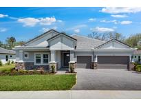Charming single-story home with a well-manicured lawn, two-car garage, and inviting stone accents at 2975 Arranmore Dr, Ormond Beach, FL 32174