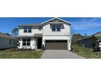 Charming two-story home features a gray exterior, well-maintained lawn, and a two-car garage at 5425 Log Grove Ln, Orlando, FL 32829