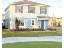 Two-story house with light blue and white siding, landscaping, and a driveway at 10876 Waterwood Aly, Orlando, FL 32829