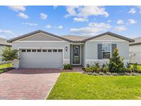 Gray house with a two-car garage and a landscaped front yard at 1365 Hanoverian Dr, Lake Alfred, FL 33850