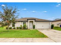 Inviting single-story home featuring a well-maintained lawn, enhanced curb appeal and attached garage at 1952 Piedmont Ct, Mascotte, FL 34753