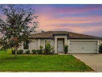 Charming single-story home featuring a well-maintained lawn, attached two car garage, and welcoming entrance at 1952 Piedmont Ct, Mascotte, FL 34753