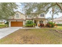 Two-story house with brown garage door, landscaping, and a spacious front yard at 3689 Rolling Hills Ln, Apopka, FL 32712