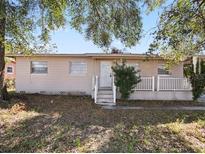 Ranch-style home with a covered porch and mature landscaping at 5614 Riviera Dr, Orlando, FL 32808