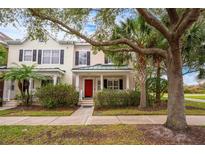 Inviting exterior of charming townhome with red door and lush landscaping at 8773 Silk Bay Pl, Orlando, FL 32827