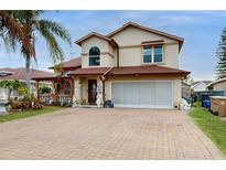 Two-story house with a brick driveway and landscaped front yard at 106 Seabreeze Cir, Kissimmee, FL 34743