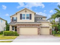 Charming two-story home featuring a two-car garage, stone accents, and a well-manicured lawn at 1416 Cabot Dr, Clermont, FL 34711