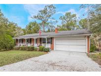 Brick ranch house with carport, front porch, and mature landscaping at 15941 Sw 8Th Pl, Ocala, FL 34481