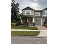 Two-story townhome with attached garage and front landscaping at 16307 Old Ash Loop, Orlando, FL 32828