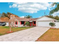 Tan house with red accents, a white fence, and a driveway at 1806 Crownwood Dr, Orlando, FL 32810